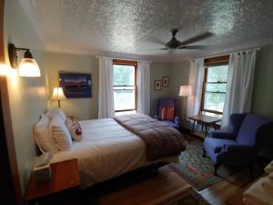 a bedroom with a bed and a blue chair at Keene Valley Lodge in Keene Valley