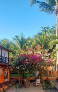 un jardín con flores en un banco y palmeras en Vila Charme, en Jericoacoara