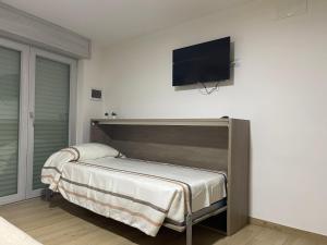 een slaapkamer met een bed en een flatscreen-tv aan de muur bij Teddy'sRoom in Nocera Superiore