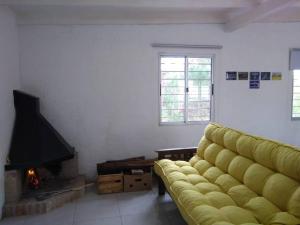 a living room with a yellow couch and a fireplace at Casa en La Esmeralda Uruguay in La Esmeralda 
