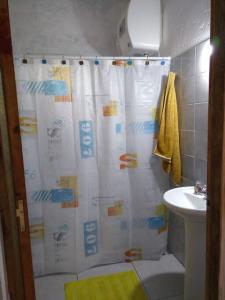 a bathroom with a shower curtain and a sink at Casa en La Esmeralda Uruguay in La Esmeralda 