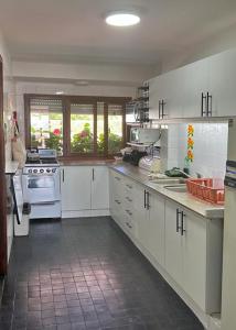 a kitchen with white cabinets and white appliances at Departamento Mar Punta del Este in Punta del Este