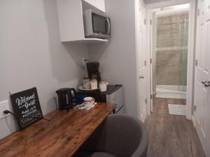 eine kleine Küche mit einem Holztisch und einem TV in der Unterkunft Splendid Place in Kingston