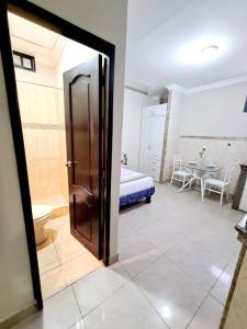 une pièce avec une chambre avec un lit et une table dans l'établissement Estudio D2 Riocentro Norte-Mall Del Rio Samanes, à Guayaquil