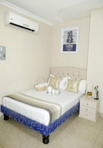 - une chambre blanche avec un lit et un mur blanc dans l'établissement Estudio D2 Riocentro Norte-Mall Del Rio Samanes, à Guayaquil