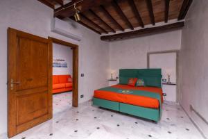- une chambre avec un lit orange et vert dans l'établissement IBibiena - SUITE DEL CARDINALE, à Bibbiena