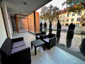 Un balcón con sillas y mesas en un edificio en Argo Apartments, en Liubliana