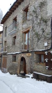 um grande edifício de pedra com uma porta na neve em CASA DONDELA em Roní