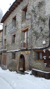 a large stone building with a door in the snow at CASA DONDELA in Roní