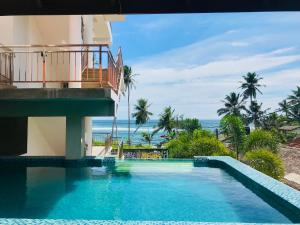a resort swimming pool with a view of the ocean at Resort Deepika Mirissa in Mirissa