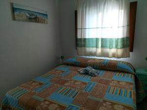 1 dormitorio con 1 cama con edredón en Stazzo vista mare, en San Teodoro