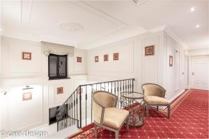 a staircase with two chairs and a table in a house at Hotel Versay in Băile Herculane