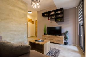 a living room with a tv and a couch and a table at Apartman Maslacak in Divčibare