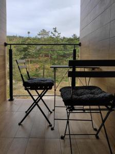 two chairs and a table on a balcony with a view at Apartman Maslacak in Divčibare
