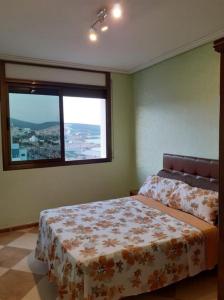 - une chambre avec un lit et une grande fenêtre dans l'établissement Residence La corniche Étage 4, à Nador