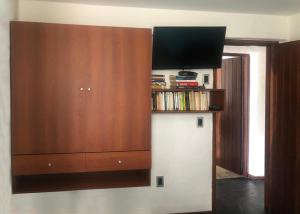 a large wooden cabinet with a flat screen tv at Departamento Mar Punta del Este in Punta del Este +14 photos
