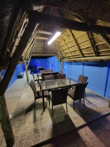 a dining room with a glass table and chairs at La-Nuel Guest Lodge in Boksburg