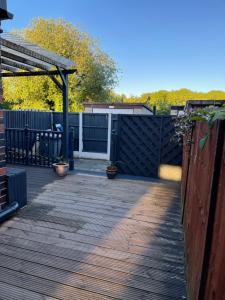 una terraza de madera con una puerta y una valla en Green Villa en Hickleton