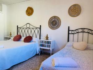 a bedroom with two beds and a table and a shelf at Ca Àngela in Bolulla