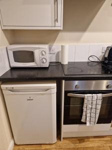 a kitchen with a microwave oven and a stove at Chique Maidstone Studio III in Kent