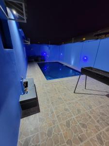 a swimming pool in a room with blue lighting at La-Nuel Guest Lodge in Boksburg