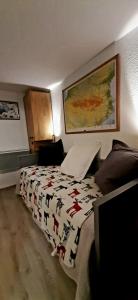 Appartement 4 personnes Porté Puymorens في بورتيه بيومورينز: غرفة نوم مع سرير مع بطانية عليها حيوانات