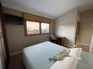 a small bedroom with a bed and a window at El Roble 9 in Astorga