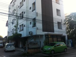 een groene auto geparkeerd voor een gebouw bij Chiangmai Tree Hostel in Chiang Mai