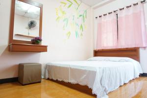 1 dormitorio con cama y espejo en Chiangmai Tree Hostel, en Chiang Mai
