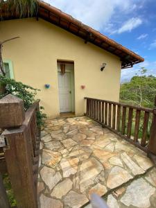 a house with a stone walkway in front of it at Chalés Lavras de Minas - Canadá in Lavras Novas