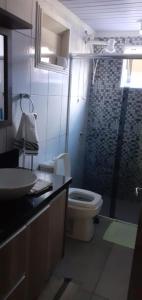 y baño con aseo y lavamanos. en Casa de praia, en Florianópolis