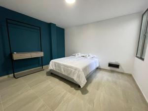 1 dormitorio con cama y pared azul en Work space Hostal, en Uribia