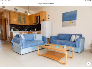 uma sala de estar com dois sofás azuis e uma mesa em Country house with amazing sea view em Kassandria
