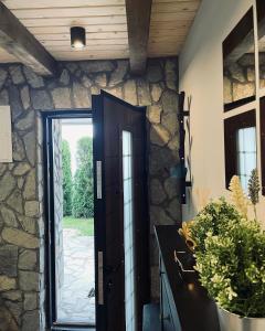 a door leading into a kitchen with a stone wall at Mount House Mavrovo in Mavrovo