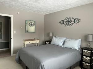 um quarto com uma cama grande e lençóis brancos em Sunny Shuswap B&B em Chase