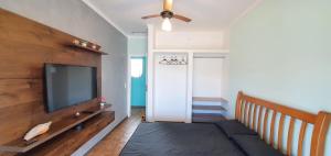 Una sala de estar con un televisor de pantalla plana en una pared. en Sobrado no Melhor Local do Indaiá, en Caraguatatuba