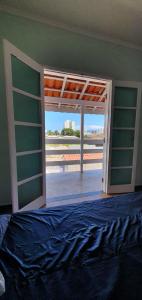 una puerta abierta a un dormitorio con cama y balcón en Sobrado no Melhor Local do Indaiá, en Caraguatatuba