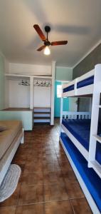 Un dormitorio con dos literas y un ventilador de techo. en Sobrado no Melhor Local do Indaiá, en Caraguatatuba