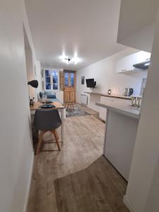 an open kitchen and living room with white countertops at HeberGenève : Aux pieds du château in Gex