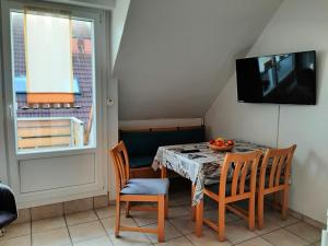 uma sala de jantar com uma mesa e cadeiras e uma televisão em Fewo Klabautermann em Norddeich