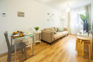 ein Wohnzimmer mit einem Sofa und einem Tisch in der Unterkunft CARTAGENAFLATS, Apartamentos Anfiteatro Romano 4B in Cartagena
