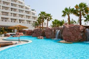a swimming pool with a waterfall in a resort at Leonardo Plaza Hotel Eilat in Eilat