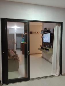 a room with a sliding glass door with a living room at Casa de Praia Lado Sul in Guriri