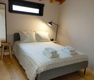 a bedroom with a bed with towels on it at Casa d´ Avó Glória in Alvoco das Várzeas +3 photos