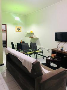 uma sala de estar com um sofá e cadeiras e uma televisão em Casas Aracaju Temporada em Aracaju