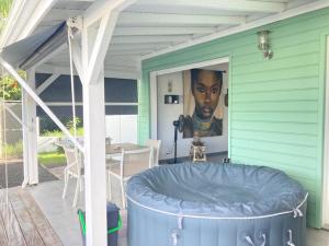 a hot tub on a patio with a painting on the wall at Appartement Shenandoah in Sainte-Anne
