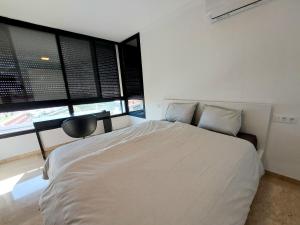 a bedroom with a large white bed and a chair at Villa Playa Amadores - Luxury villa with heated pool in Puerto Rico de Gran Canaria