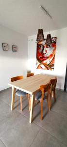 una mesa de madera con sillas y una pintura en la pared en Plus Playa Unión en Playa Unión