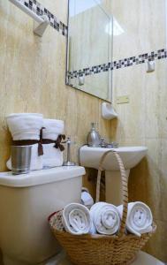y baño con aseo, lavabo y cesta. en Suite Ejecutiva 2F A 12Min Malecon 2000 GYE, en Guayaquil
