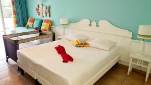 un dormitorio con una cama con un animal de peluche rojo en Studio Premium Vue Mer, Plage, en Sainte-Luce
